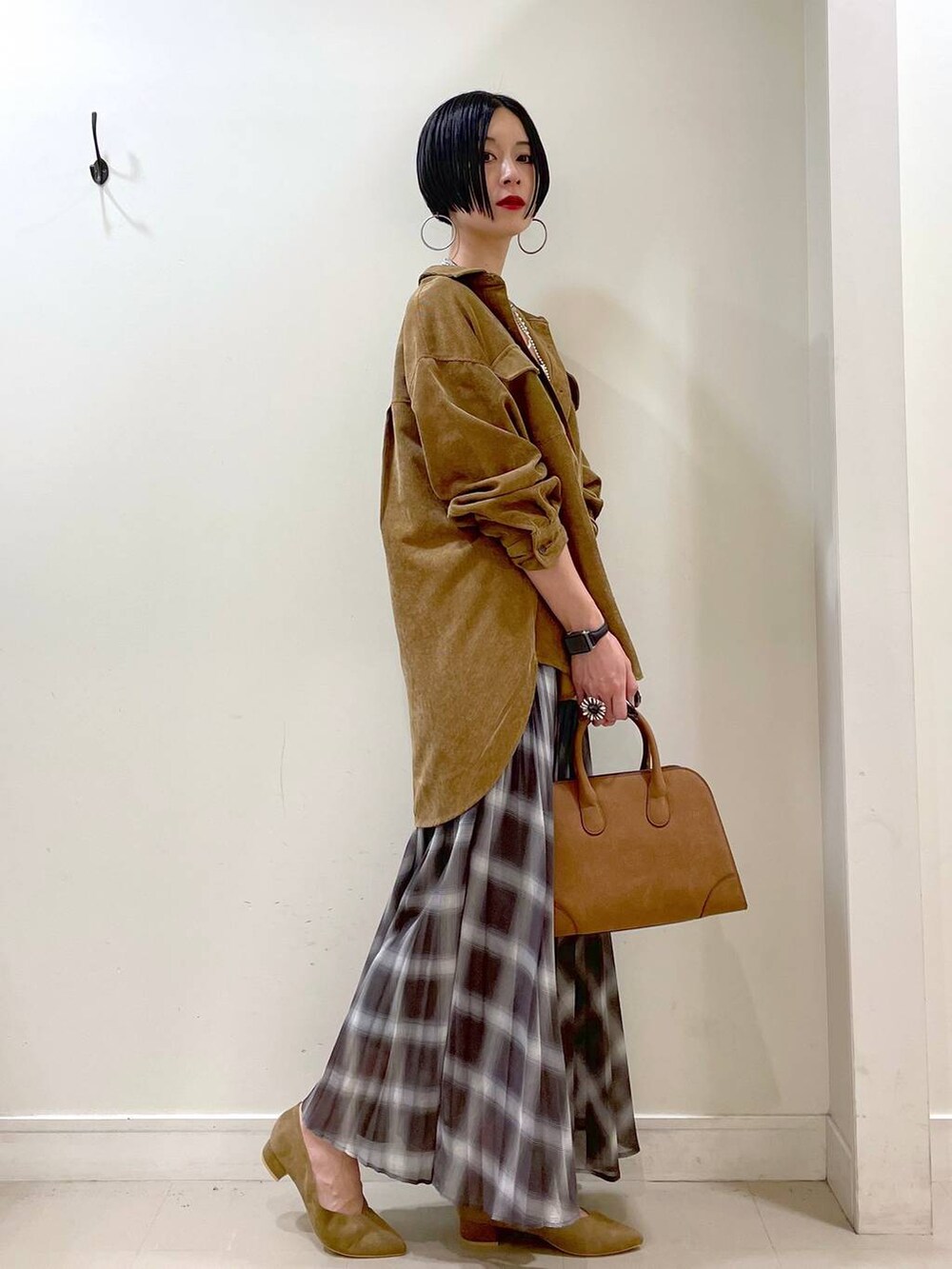 ホワイト系のキャミソール、イエロー系のシャツ/ブラウス、ブラウン系のスカートを着用したレディースの秋コーディネートの3枚目の写真