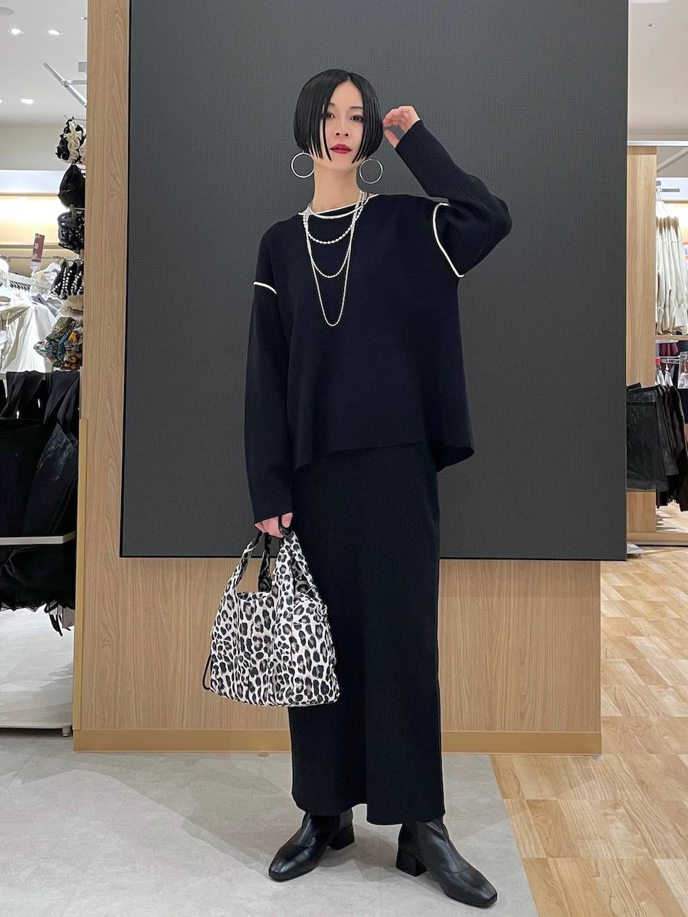 その他のトートバッグ、ブラック系のワンピース、ブラック系のブーツを着用したレディースの冬コーディネートの2枚目の写真