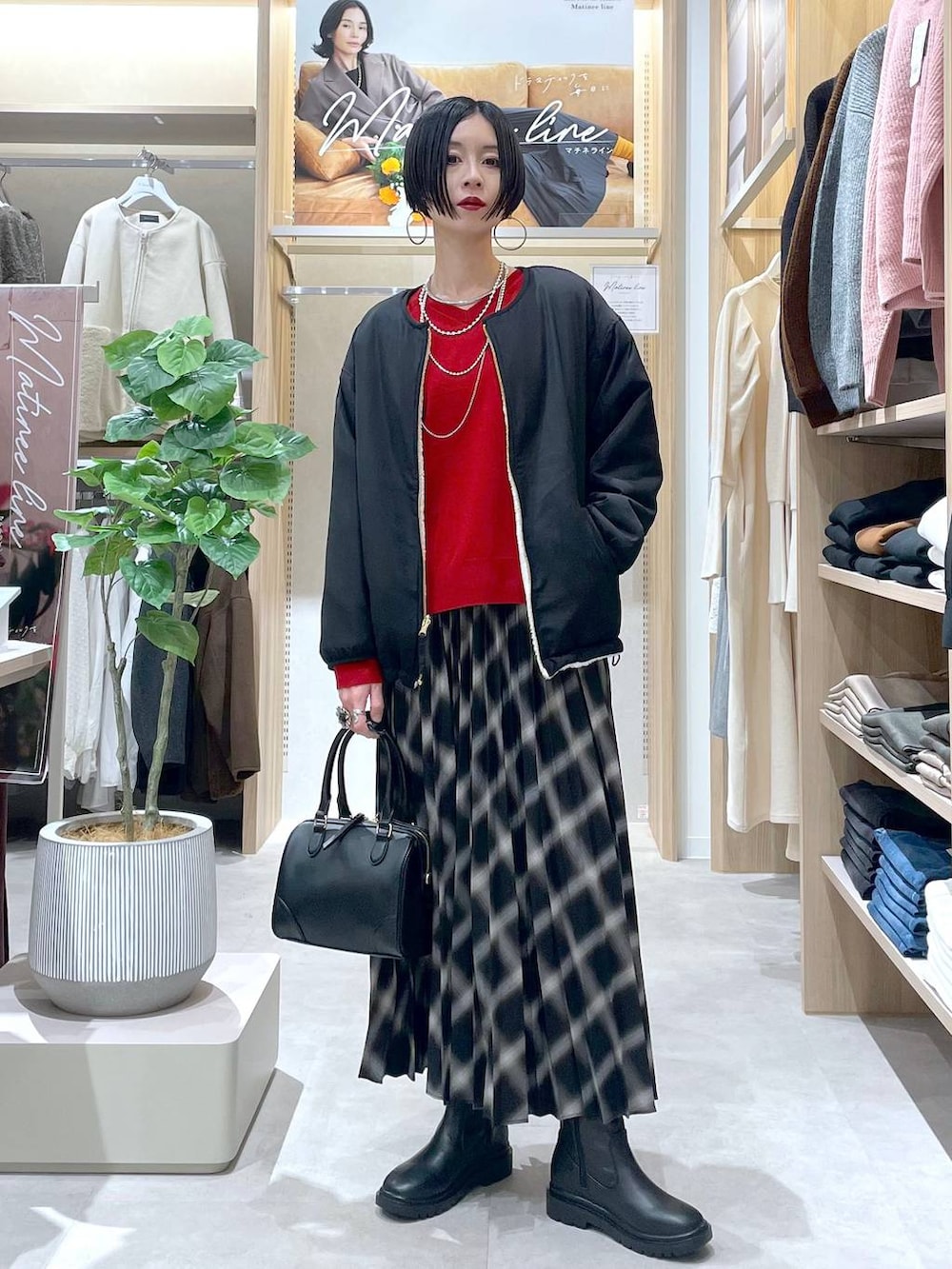 ホワイト系のブルゾン、ブラック系のブーツ、レッド系のニット/セーターを着用したレディースの秋コーディネートの4枚目の写真