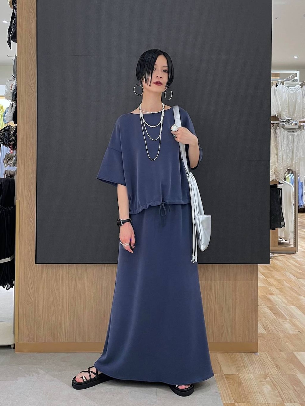 ブラック系のサンダル、ブルー系のTシャツ/カットソー、ブルー系のスカートを着用したレディースの夏コーディネートの6枚目の写真