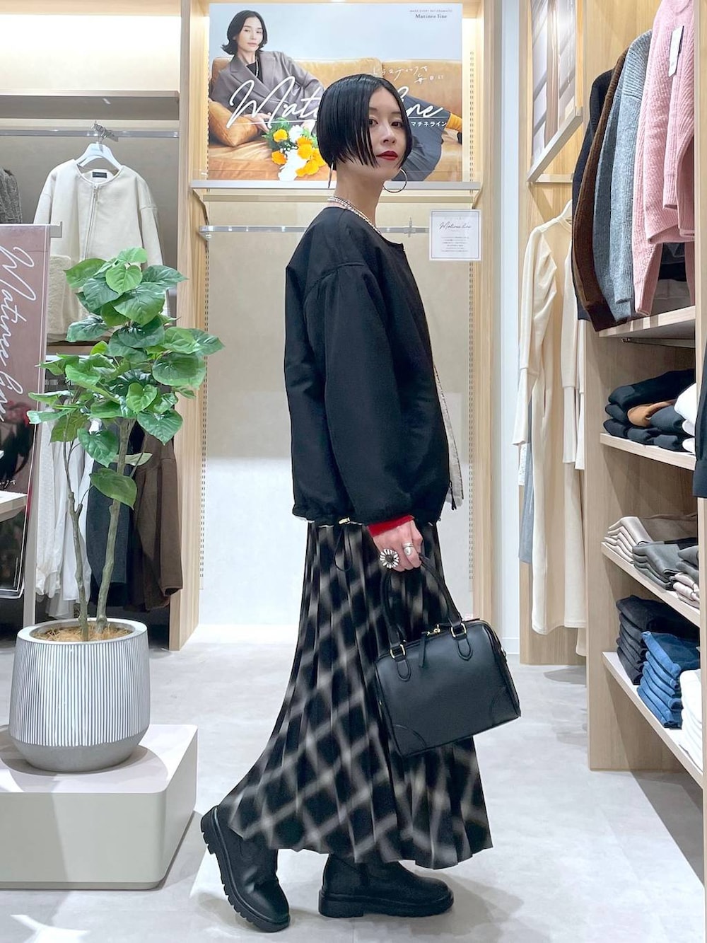 ホワイト系のブルゾン、ブラック系のブーツ、レッド系のニット/セーターを着用したレディースの秋コーディネートの2枚目の写真