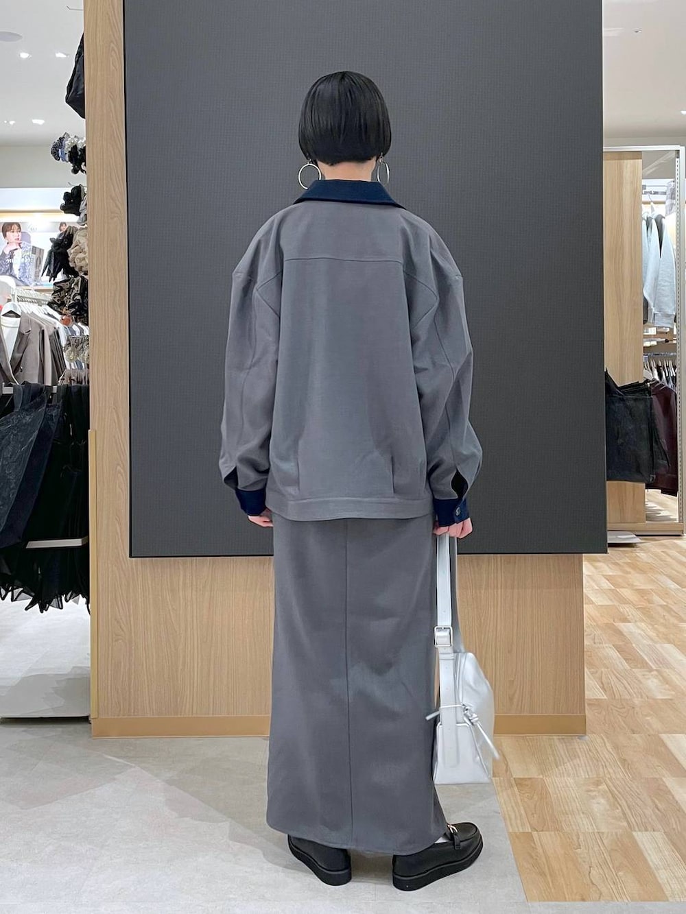 ブラック系のローファー、ブルー系のニット/セーター、シルバー系のショルダーバッグを着用したレディースの春コーディネートの3枚目の写真