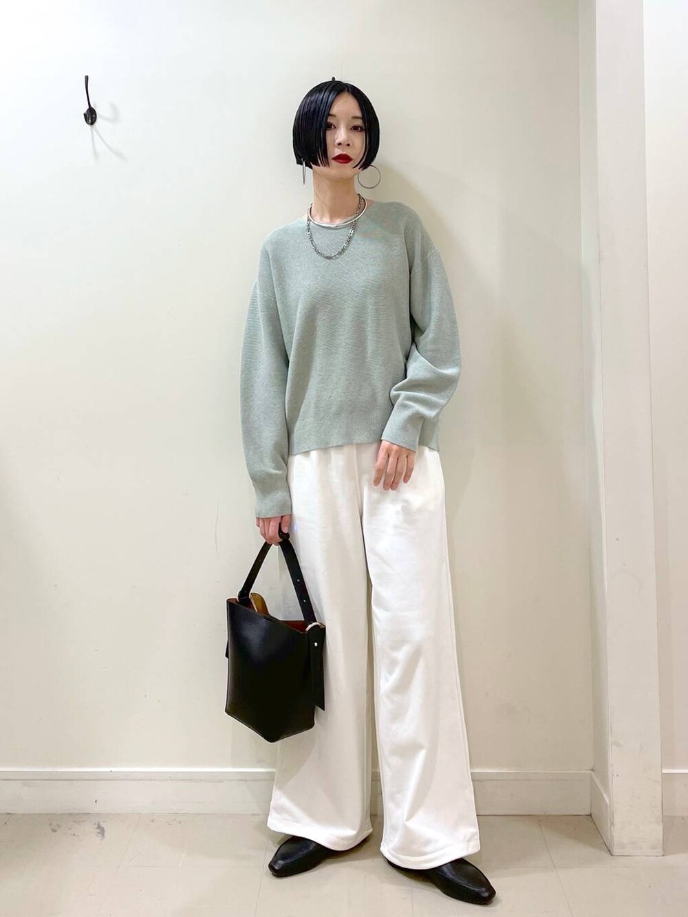 ブラック系のその他シューズ、グリーン系のマウンテンパーカー、ブラック系のショルダーバッグを着用したレディースの春コーディネートの7枚目の写真