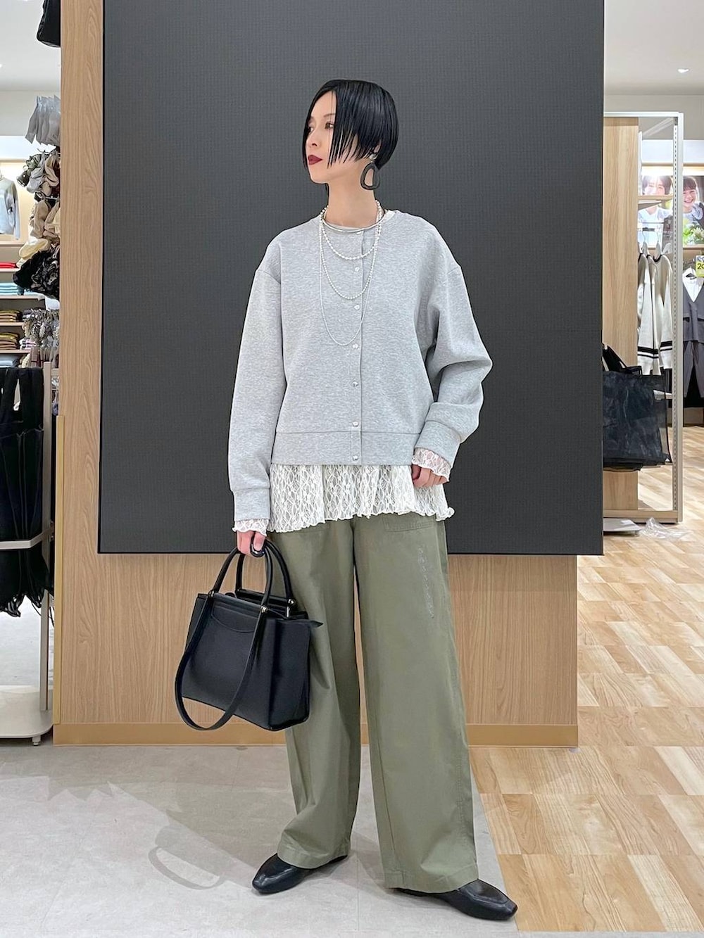 ブラック系のその他シューズ、ブラック系のトートバッグ、グレー系のカーディガン/ボレロを着用したレディースの春コーディネートの2枚目の写真