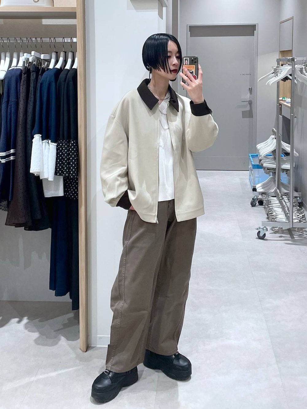 ブラウン系のデニムパンツ、ベージュ系のニット/セーター、ベージュ系のブルゾンを着用したレディースの冬コーディネートの5枚目の写真