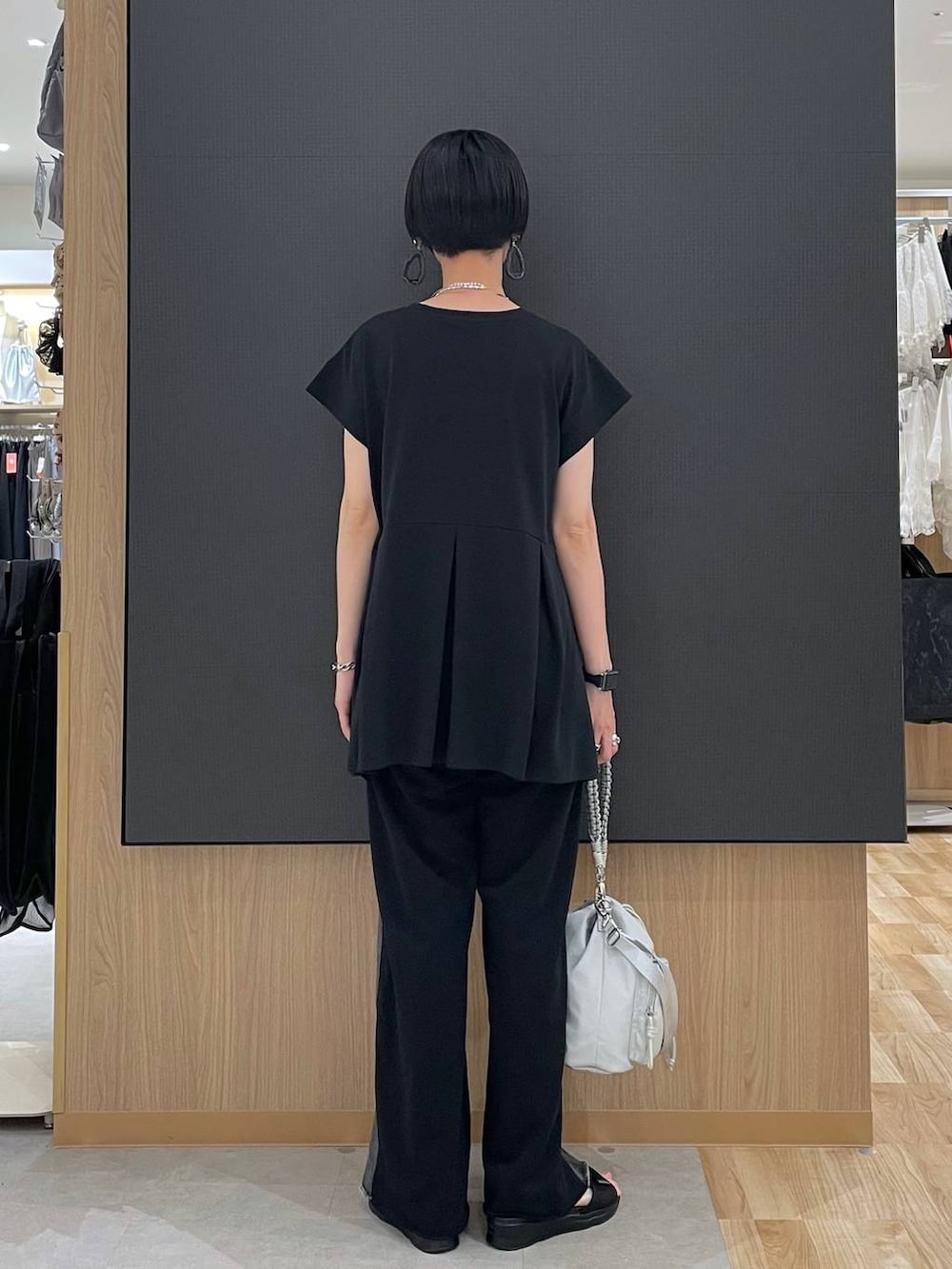 ブラック系のTシャツ/カットソー、ブラック系のサンダル、グレー系のショルダーバッグを着用したレディースの夏コーディネートの4枚目の写真
