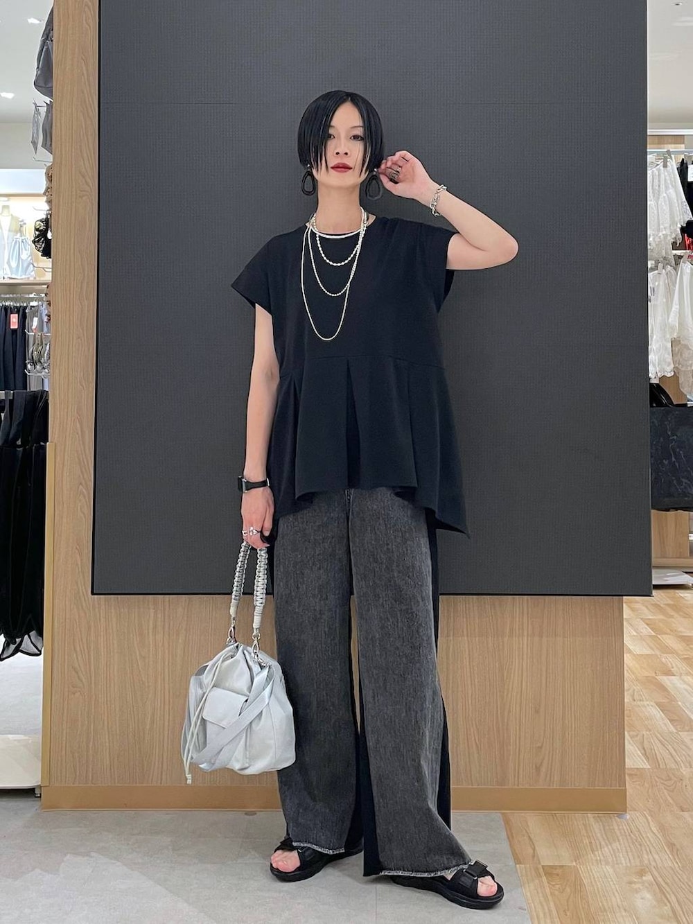 ブラック系のTシャツ/カットソー、ブラック系のサンダル、グレー系のショルダーバッグを着用したレディースの夏コーディネートの2枚目の写真