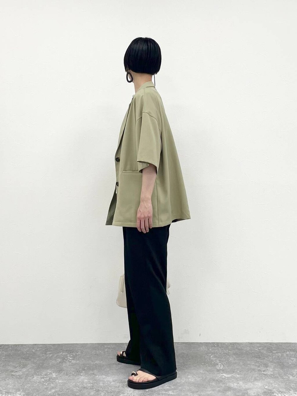 ブラック系のその他パンツ、ホワイト系のTシャツ/カットソー、ベージュ系のショルダーバッグを着用したレディースの春コーディネートの4枚目の写真