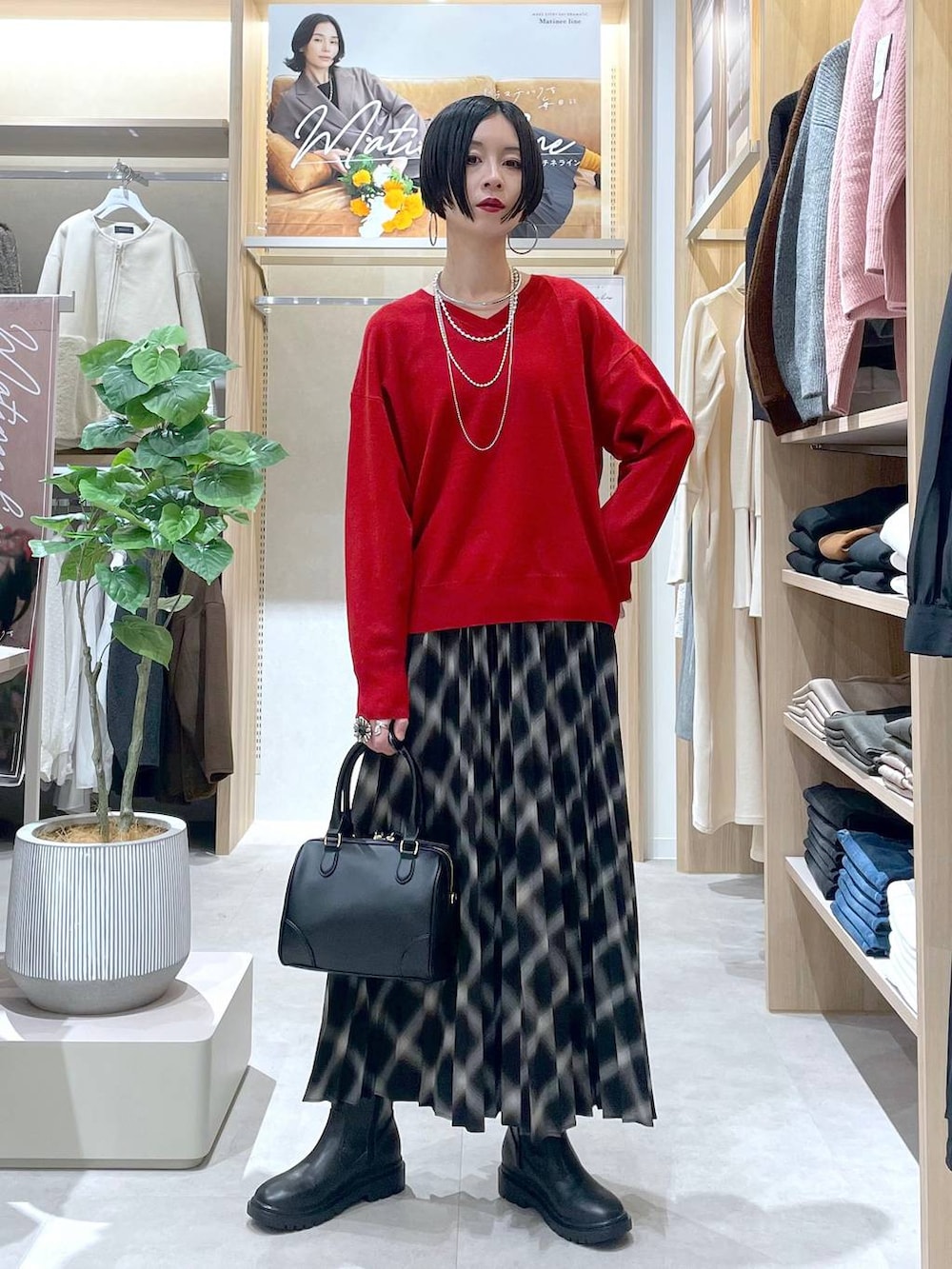 ホワイト系のブルゾン、ブラック系のブーツ、レッド系のニット/セーターを着用したレディースの秋コーディネートの8枚目の写真