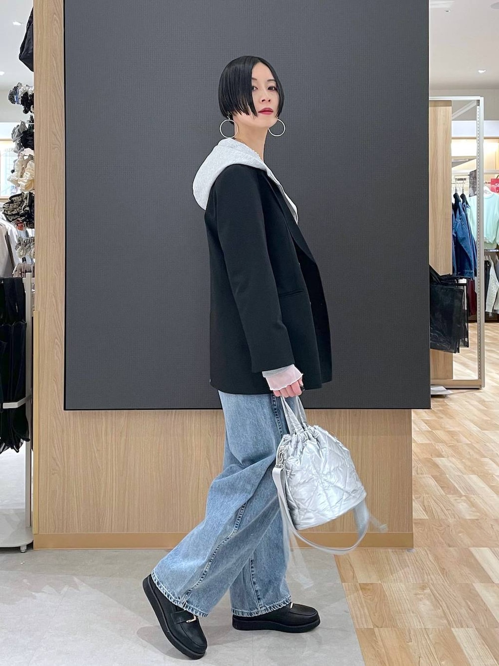 ブラック系のローファー、シルバー系のハンドバッグ、ホワイト系のTシャツ/カットソーを着用したレディースの冬コーディネートの2枚目の写真