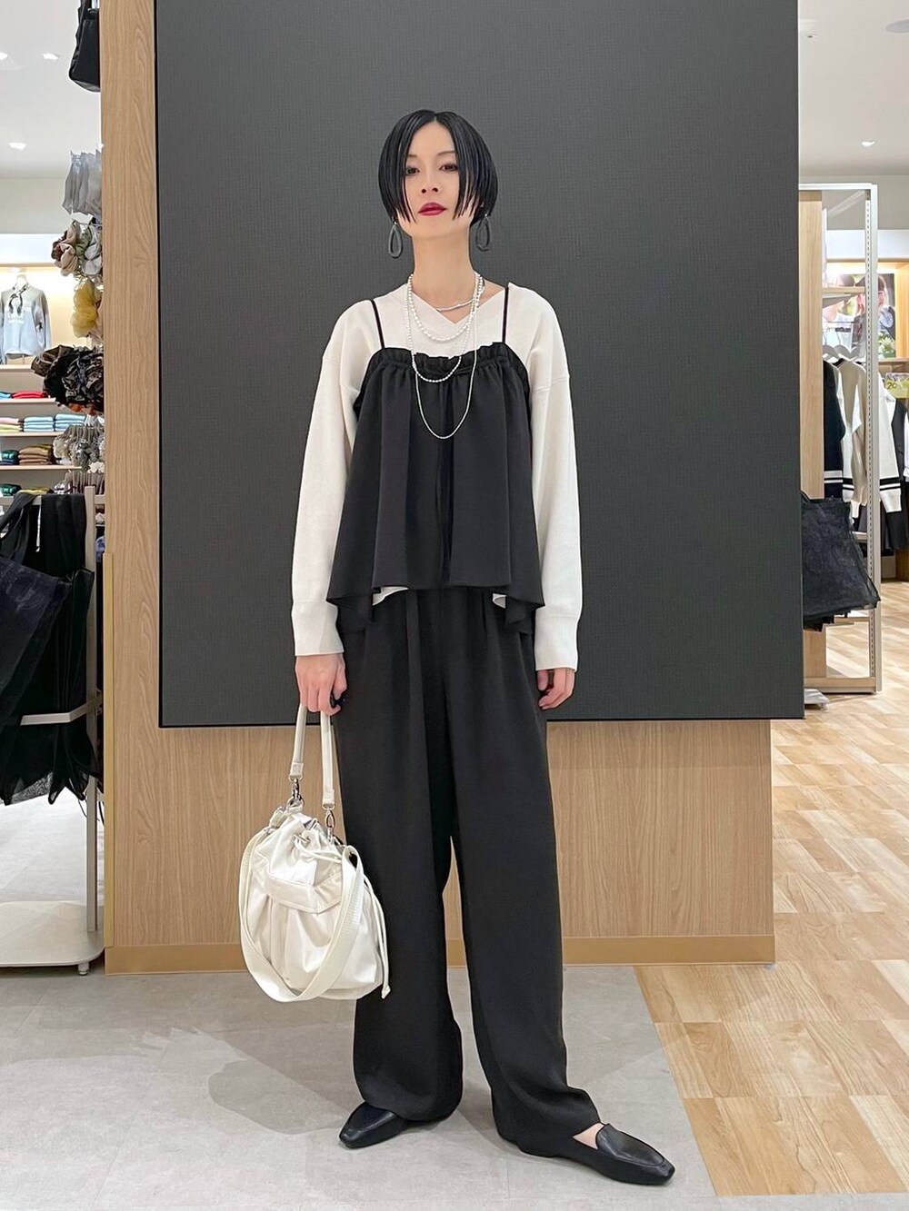 ブラック系のその他シューズ、ホワイト系のショルダーバッグ、グレー系のブルゾンを着用したレディースの春コーディネートの5枚目の写真