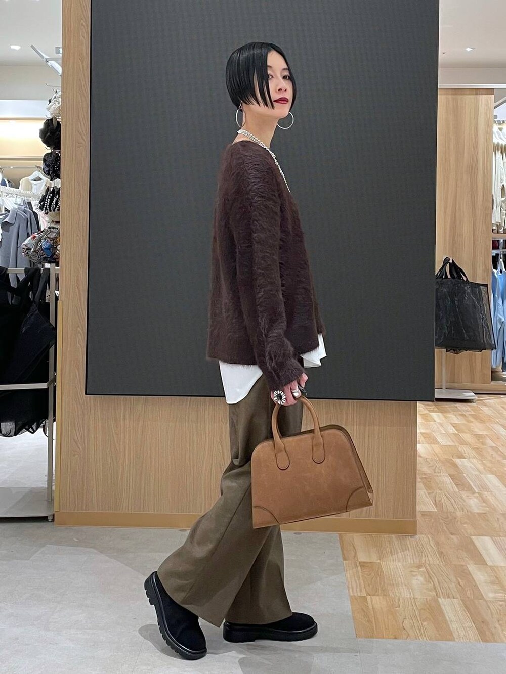 ベージュ系のダウンジャケット/コート、ブラウン系のその他パンツ、ベージュ系のショルダーバッグを着用したレディースの秋コーディネートの6枚目の写真