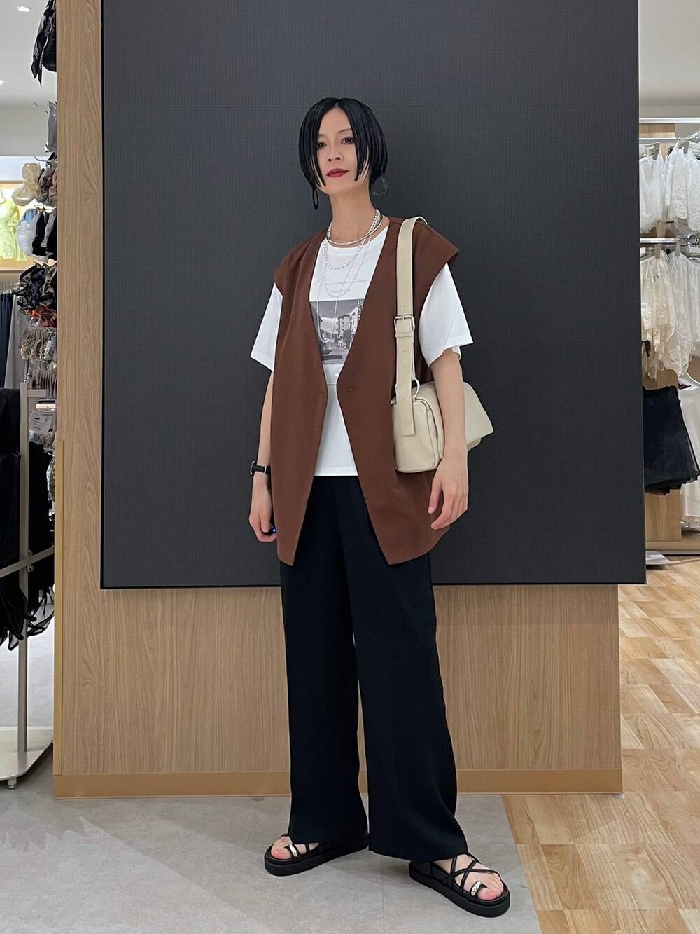 ブラック系のその他パンツ、ホワイト系のTシャツ/カットソー、ブラック系のサンダルを着用したレディースの春コーディネートの6枚目の写真