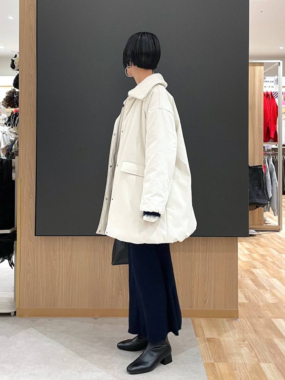 ブラック系のショルダーバッグ、ブルー系のワンピース、ブラック系のブーツを着用したレディースの冬コーディネートの5枚目の写真