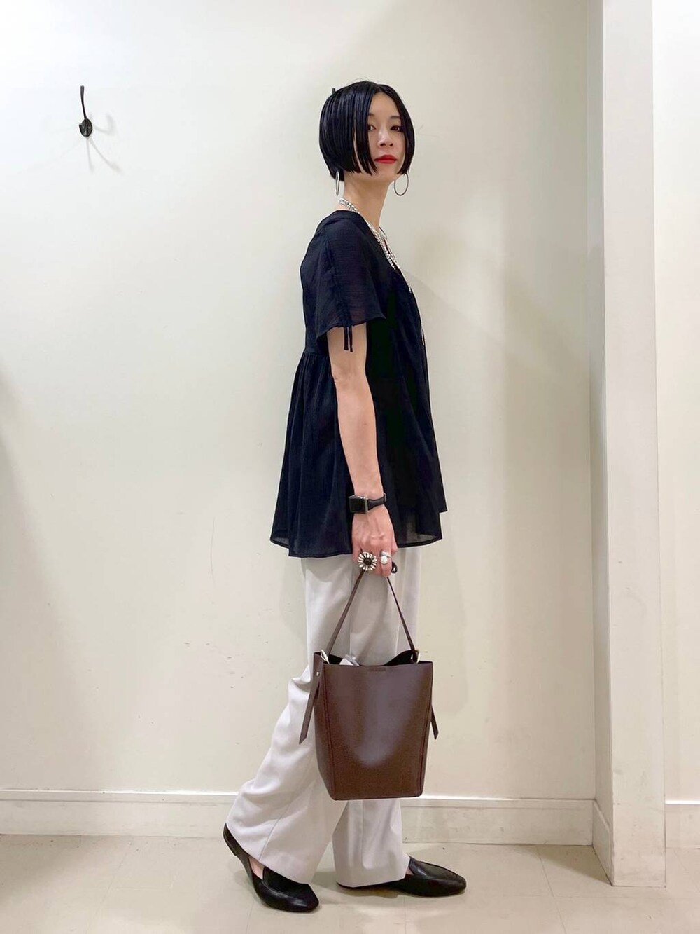 ブラック系のその他シューズ、ブラウン系のショルダーバッグ、ベージュ系のその他パンツを着用したレディースの夏コーディネートの2枚目の写真