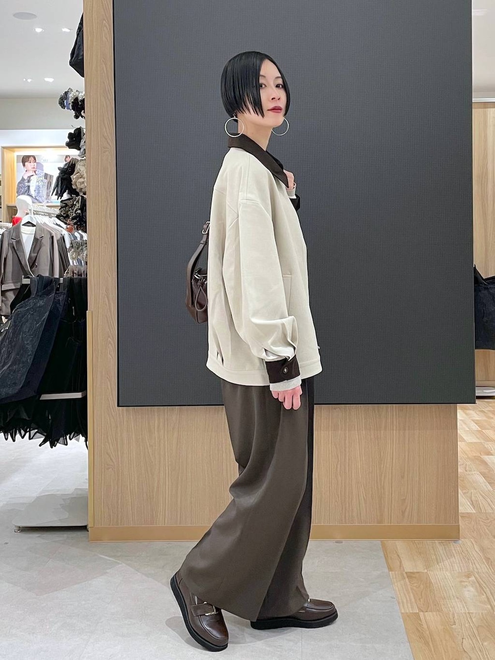 ブラウン系のローファー、ブラウン系のその他パンツ、ホワイト系のニット/セーターを着用したレディースの春コーディネートの2枚目の写真