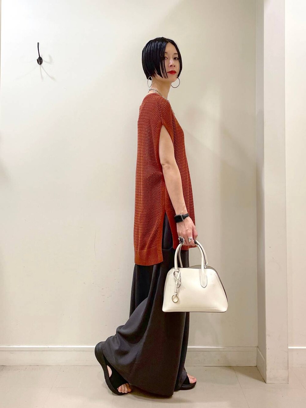 ホワイト系のショルダーバッグ、ホワイト系のキャミソール、ブラウン系のTシャツ/カットソーを着用したレディースの夏コーディネートの3枚目の写真