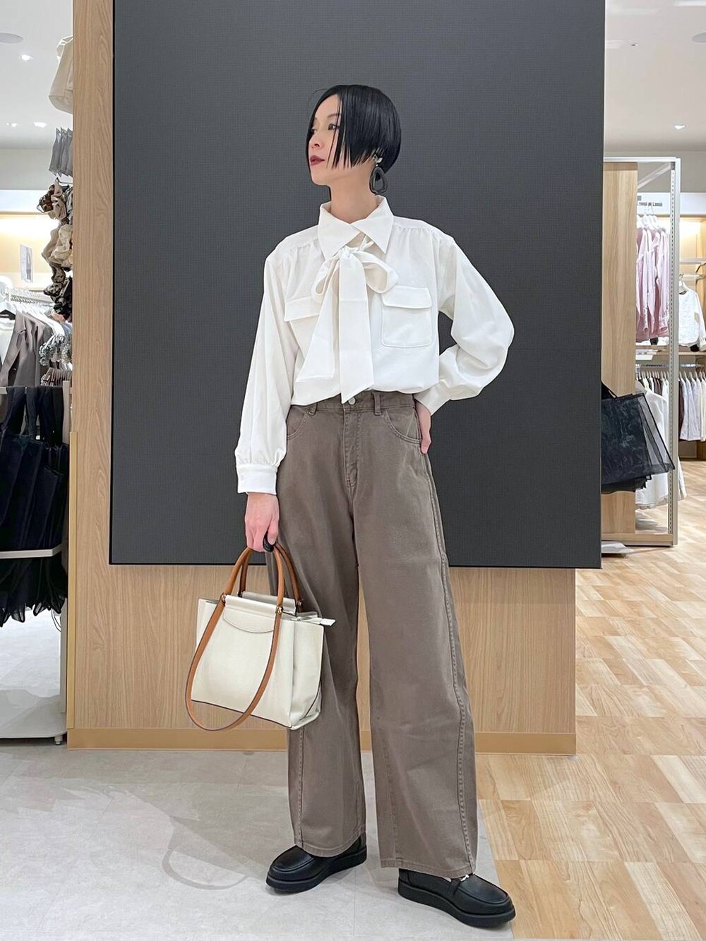 ブラック系のローファー、ブラック系のトートバッグ、ブラウン系のデニムパンツを着用したレディースの春コーディネートの7枚目の写真