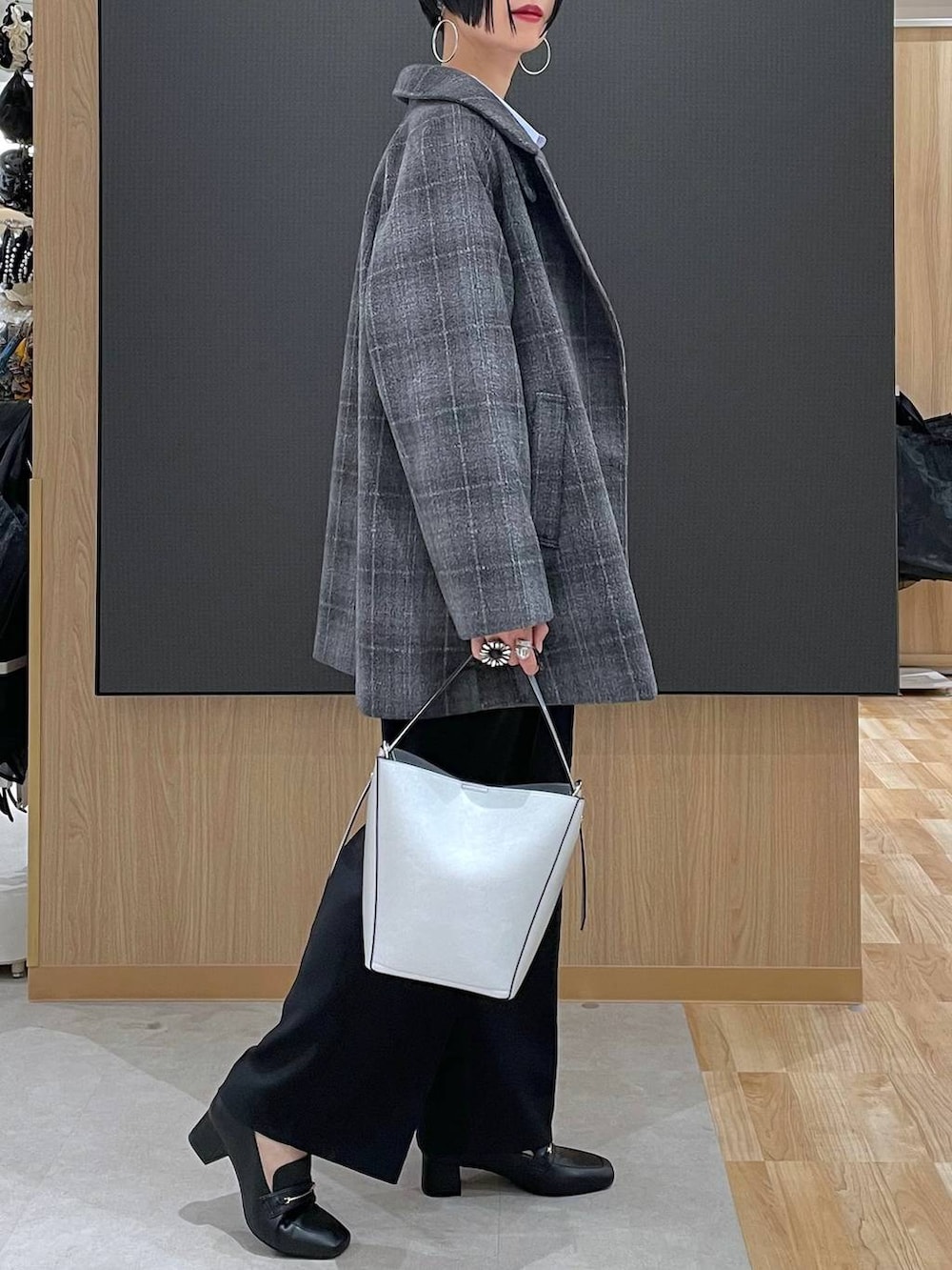 ブラック系のローファー、シルバー系のショルダーバッグ、その他のチェスターコートを着用したレディースの冬コーディネートの3枚目の写真