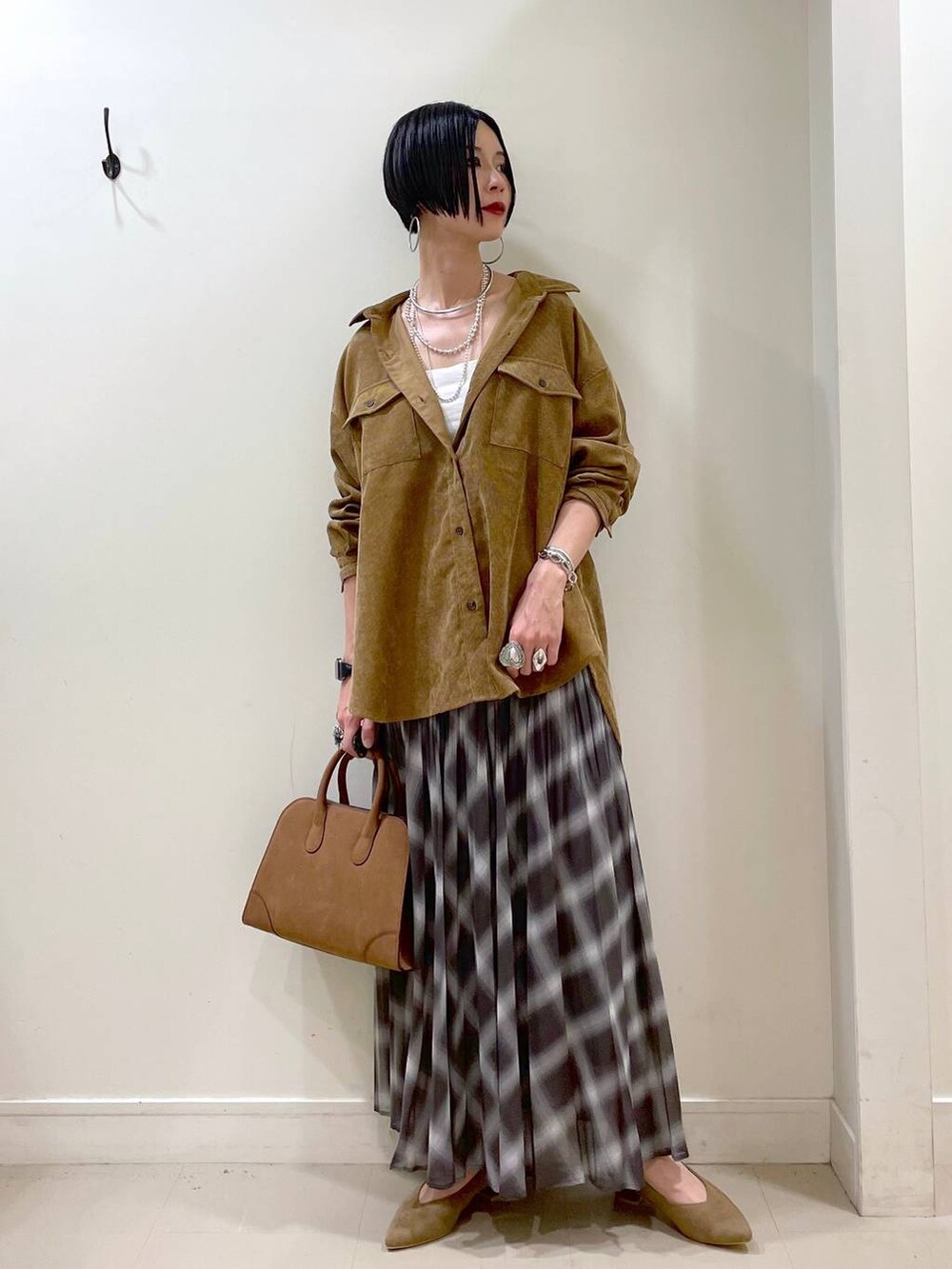 ホワイト系のキャミソール、イエロー系のシャツ/ブラウス、ブラウン系のスカートを着用したレディースの秋コーディネートの9枚目の写真