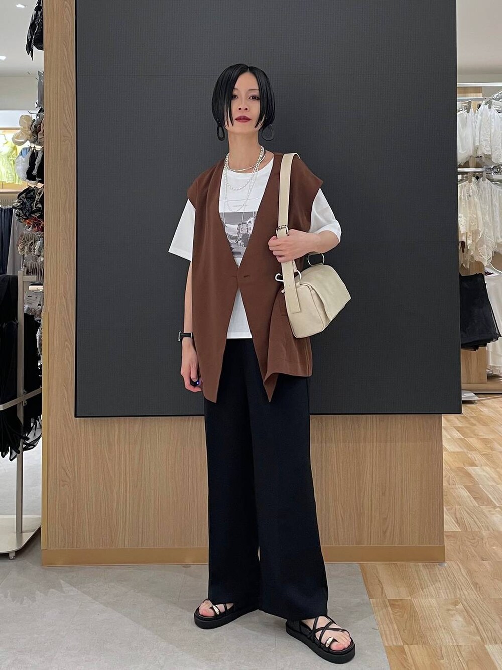 ブラック系のその他パンツ、ホワイト系のTシャツ/カットソー、ブラック系のサンダルを着用したレディースの春コーディネートの2枚目の写真