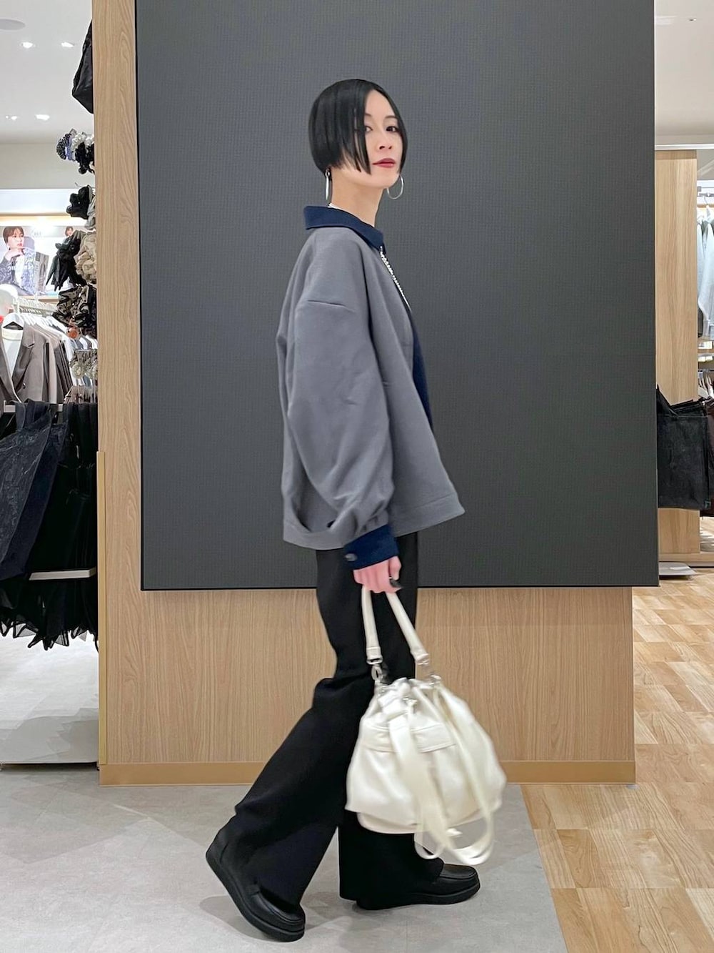 ブラック系のローファー、ホワイト系のショルダーバッグ、ブラック系のスウェットパンツを着用したレディースの春コーディネートの3枚目の写真