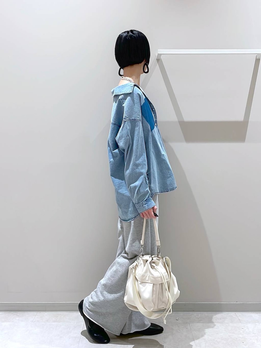 ブラック系のその他シューズ、ホワイト系のショルダーバッグ、グレー系のスウェットパンツを着用したレディースの春コーディネートの2枚目の写真