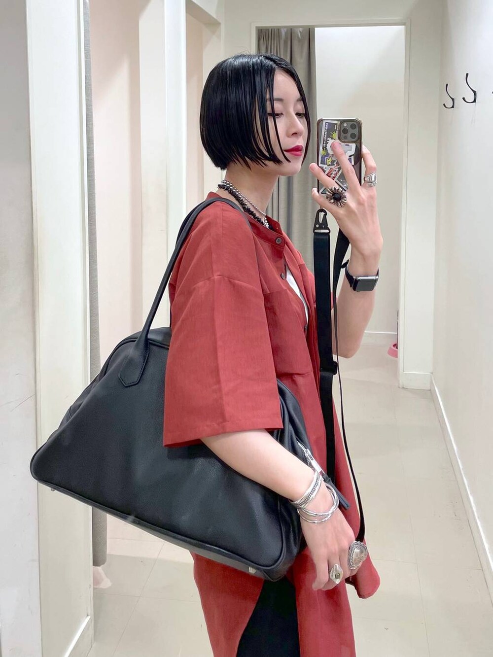 ブラック系のショルダーバッグ、ブラック系のその他パンツ、オレンジ系のシャツ/ブラウスを着用したレディースの夏コーディネートの6枚目の写真