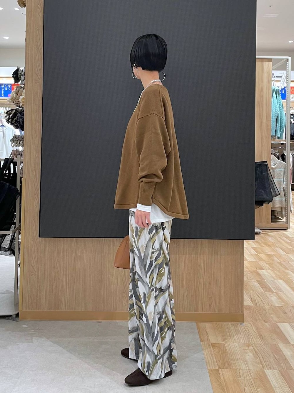 ブラウン系のショルダーバッグ、ブラウン系のニット/セーター、ブラウン系のブーツを着用したレディースの冬コーディネートの9枚目の写真