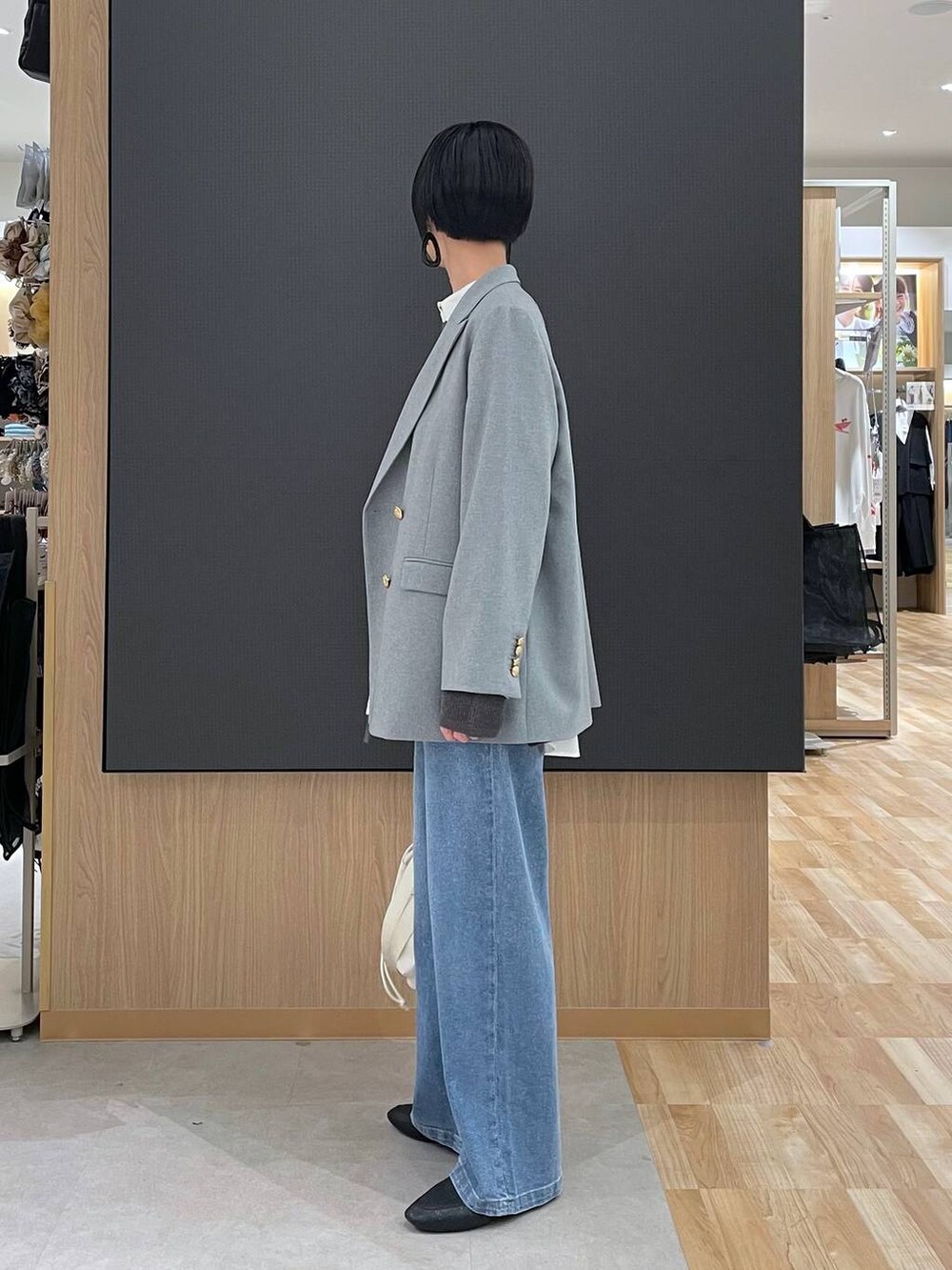 ブラック系のその他シューズ、ホワイト系のショルダーバッグ、ブルー系のデニムパンツを着用したレディースの春コーディネートの5枚目の写真
