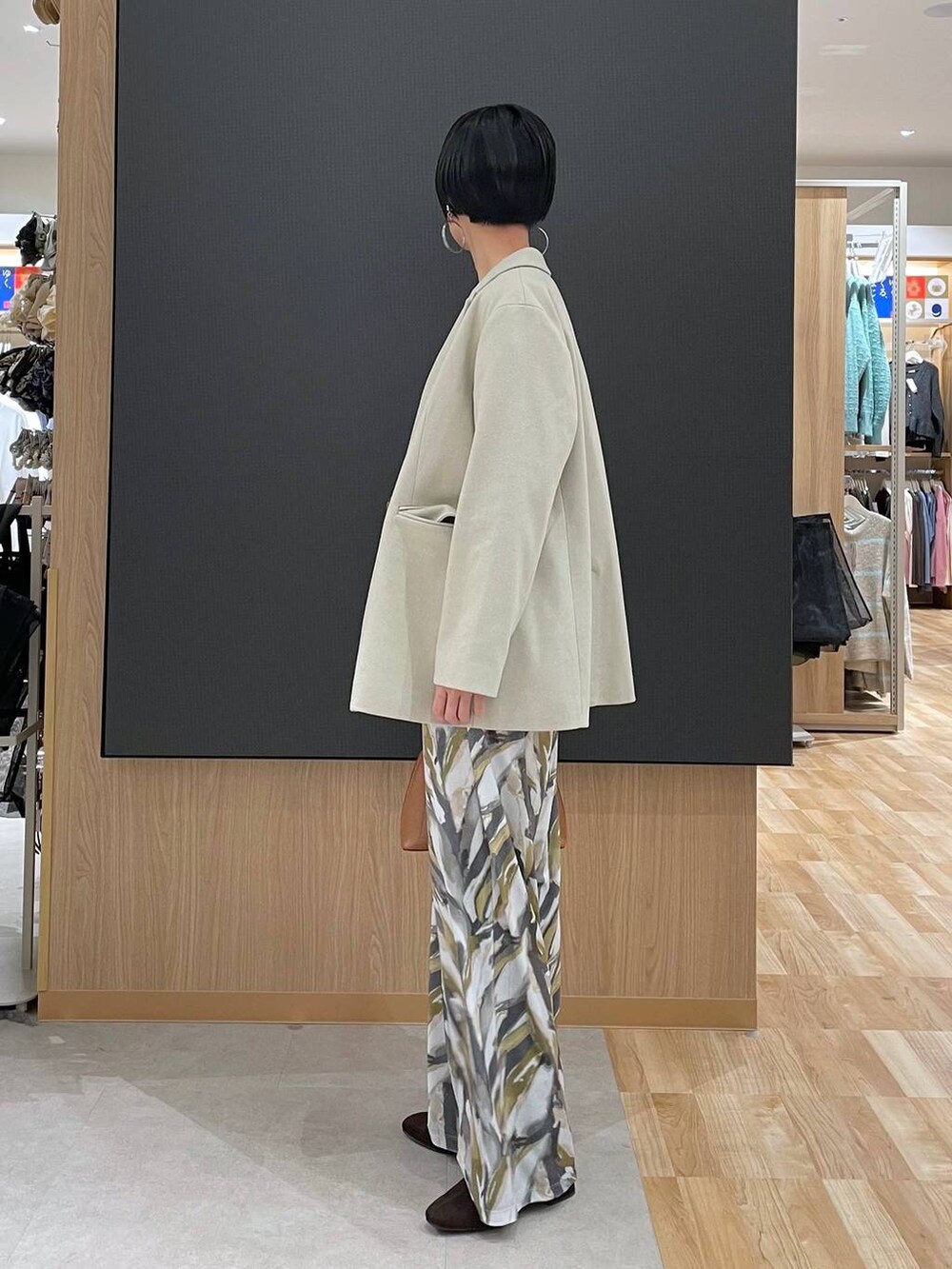 ブラウン系のショルダーバッグ、ブラウン系のニット/セーター、ブラウン系のブーツを着用したレディースの冬コーディネートの5枚目の写真