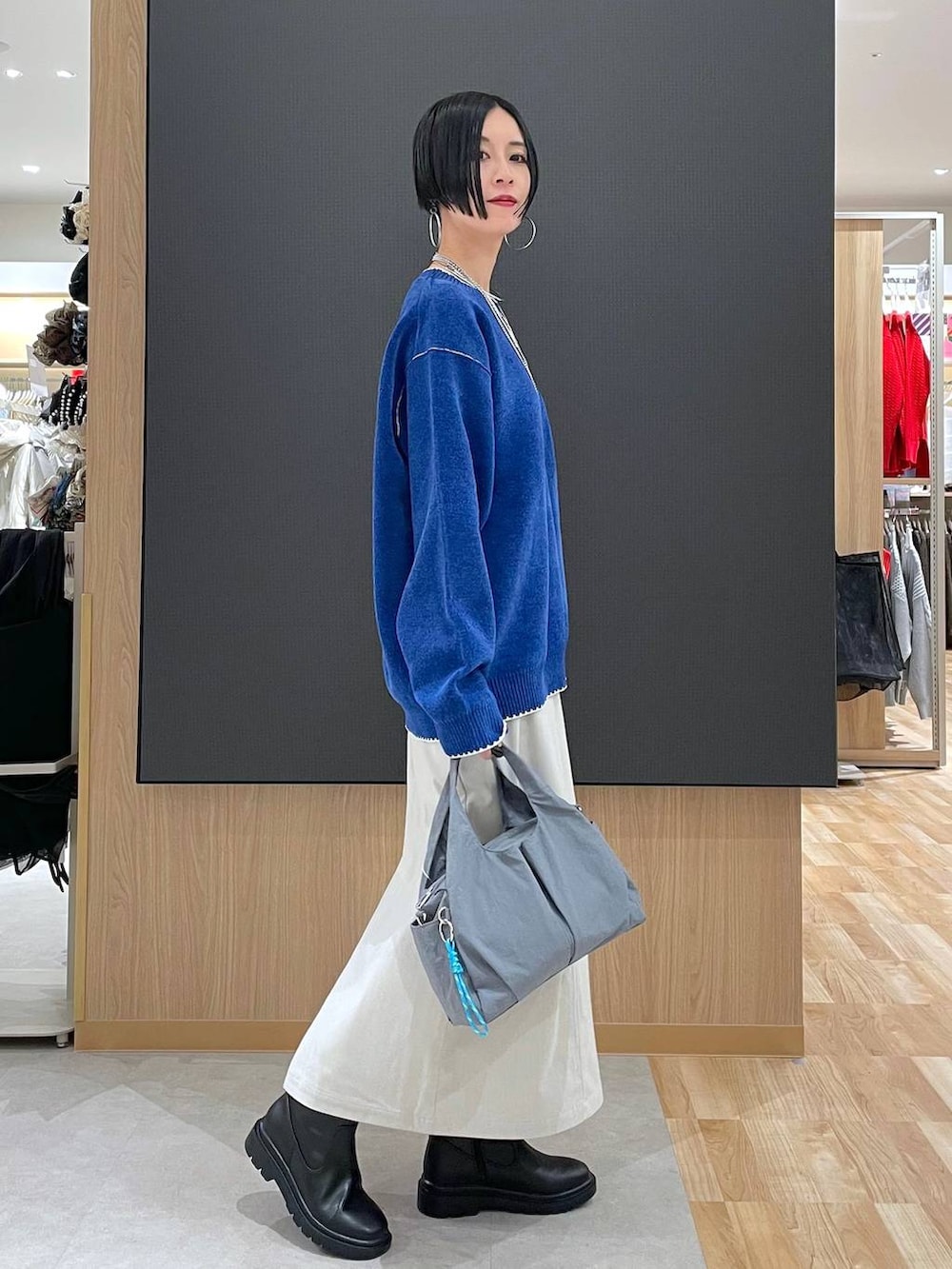 グレー系のトートバッグ、ブラック系のブルゾン、グレー系のスカートを着用したレディースの冬コーディネートの8枚目の写真