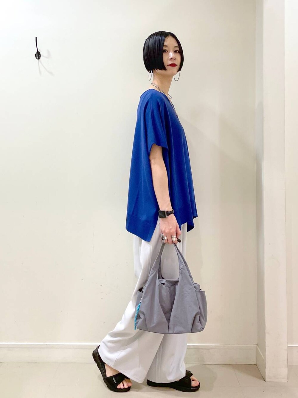 グレー系のその他パンツ、ブルー系のニット/セーター、グレー系のトートバッグを着用したレディースの夏コーディネートの3枚目の写真