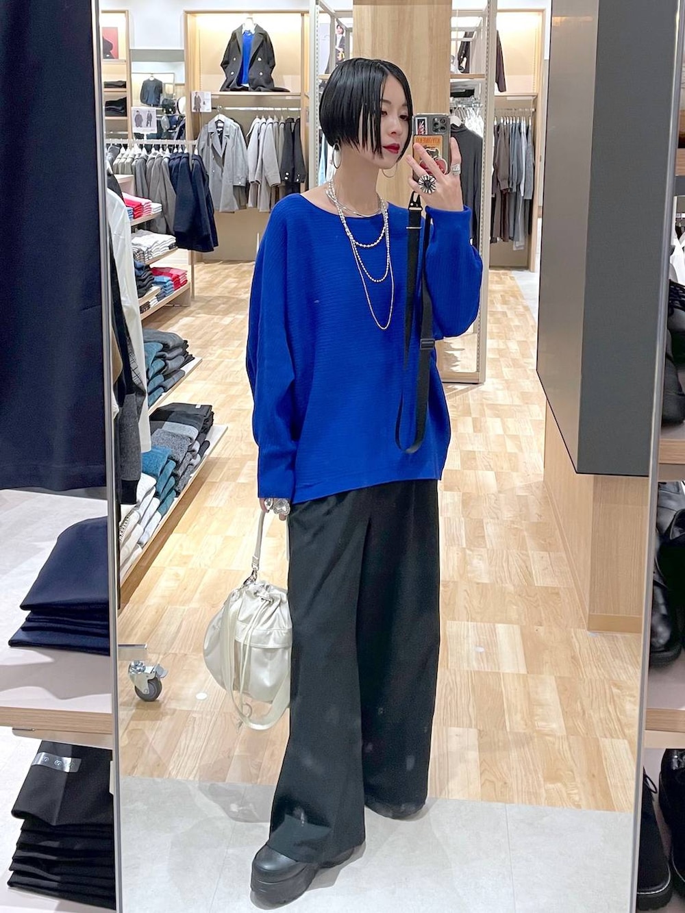 ホワイト系のショルダーバッグ、その他のチェスターコート、ブラック系のその他パンツを着用したレディースの秋コーディネートの9枚目の写真