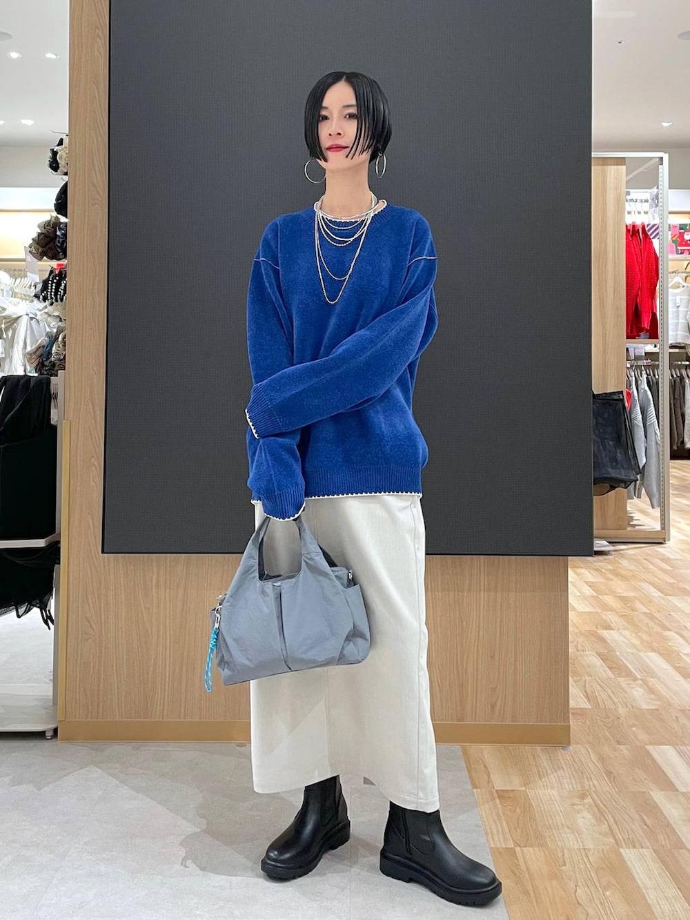 グレー系のトートバッグ、ブラック系のブルゾン、グレー系のスカートを着用したレディースの冬コーディネートの7枚目の写真