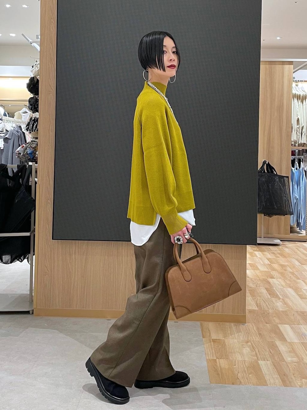 ベージュ系のダウンジャケット/コート、ブラウン系のその他パンツ、ベージュ系のショルダーバッグを着用したレディースの冬コーディネートの7枚目の写真