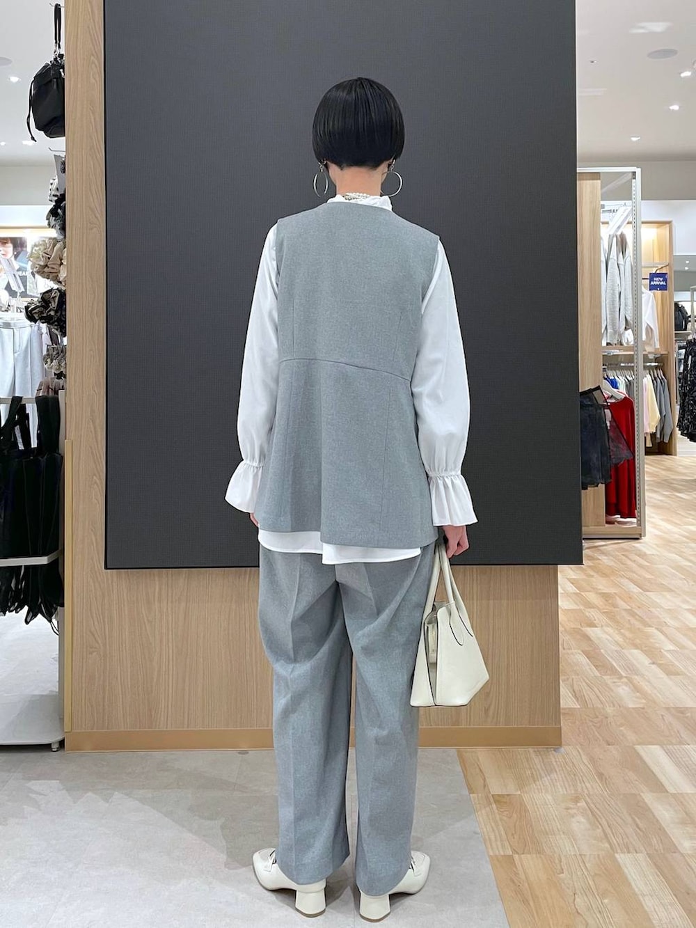 ベージュ系のローファー、ホワイト系のショルダーバッグ、グレー系のその他パンツを着用したレディースの冬コーディネートの4枚目の写真