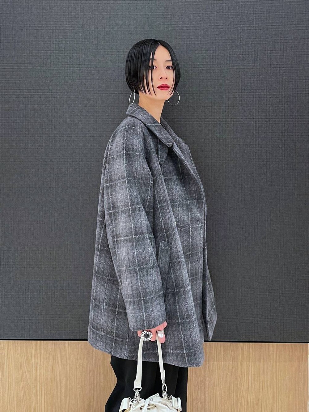 ホワイト系のショルダーバッグ、その他のチェスターコート、ブラック系のその他パンツを着用したレディースの秋コーディネートの3枚目の写真