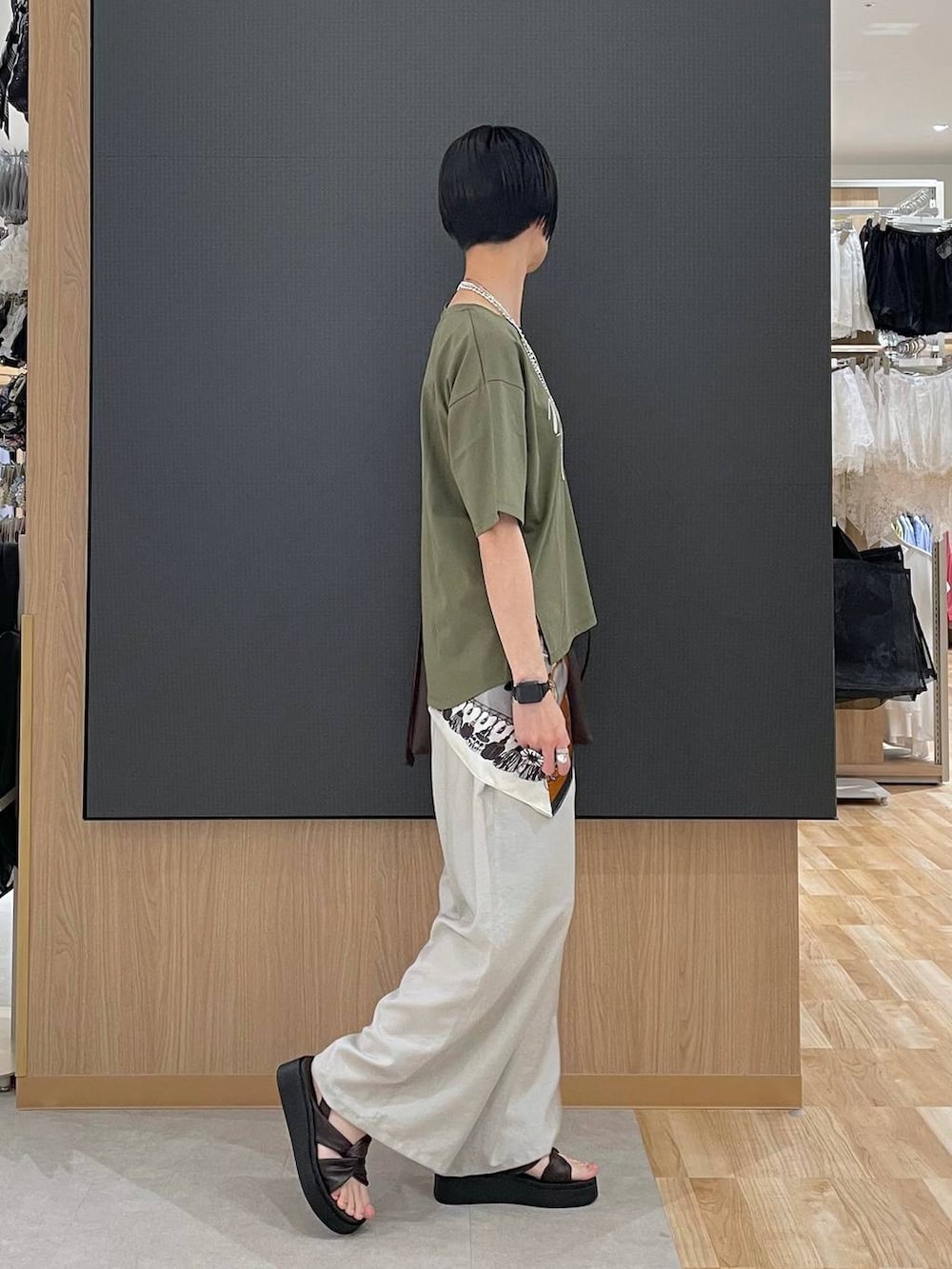 ベージュ系のその他パンツ、グリーン系のTシャツ/カットソー、ブラウン系のサンダルを着用したレディースの夏コーディネートの3枚目の写真