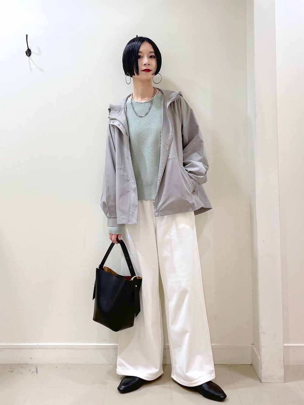 ブラック系のその他シューズ、グリーン系のマウンテンパーカー、ブラック系のショルダーバッグを着用したレディースの春コーディネートの6枚目の写真