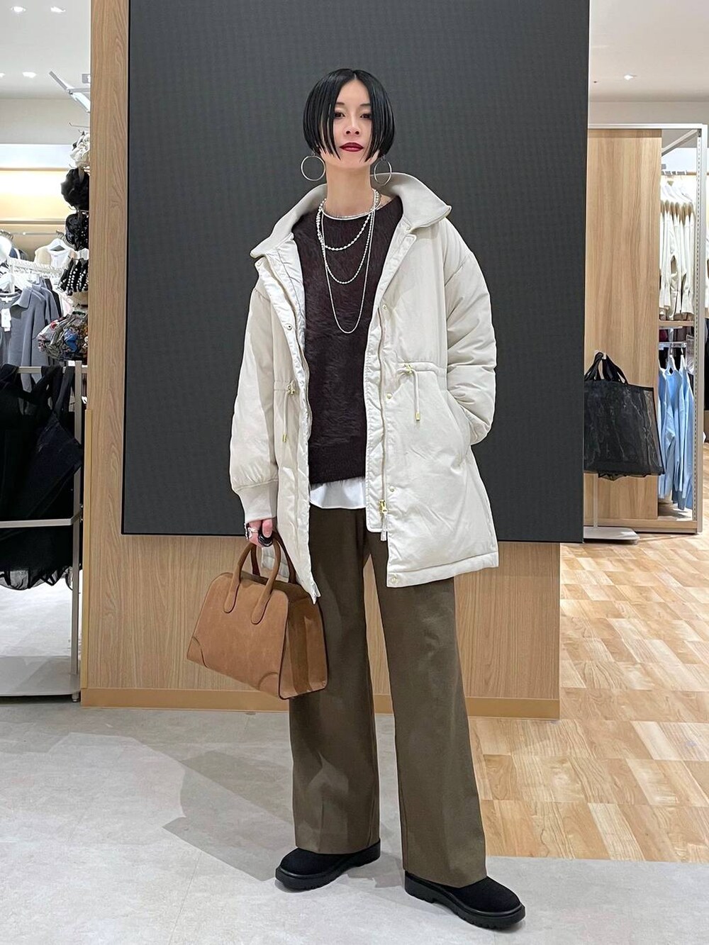 ベージュ系のダウンジャケット/コート、ブラウン系のその他パンツ、ベージュ系のショルダーバッグを着用したレディースの秋コーディネートの9枚目の写真