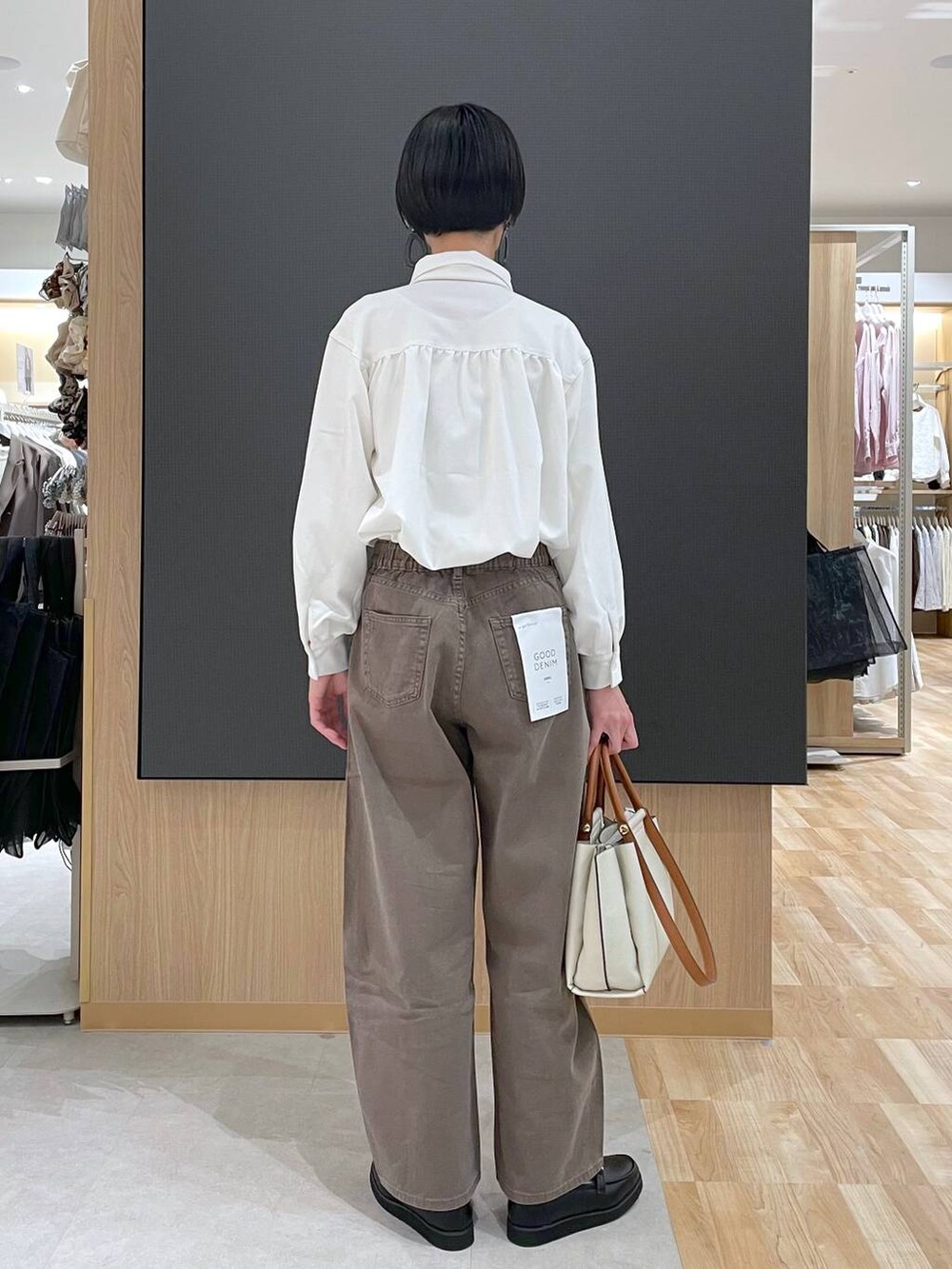 ブラック系のローファー、ブラック系のトートバッグ、ブラウン系のデニムパンツを着用したレディースの春コーディネートの9枚目の写真