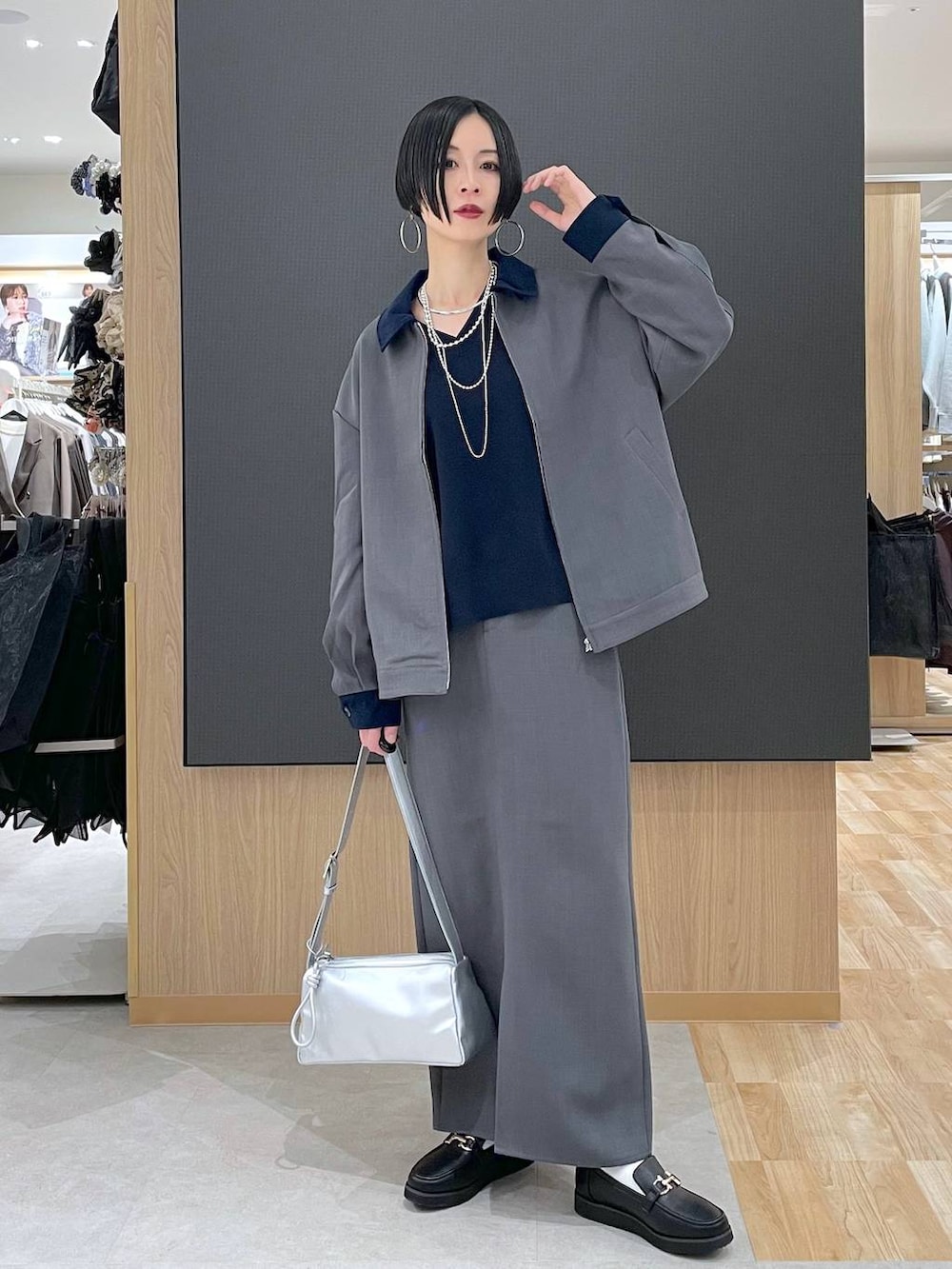 ブラック系のローファー、ブルー系のニット/セーター、シルバー系のショルダーバッグを着用したレディースの春コーディネートの5枚目の写真