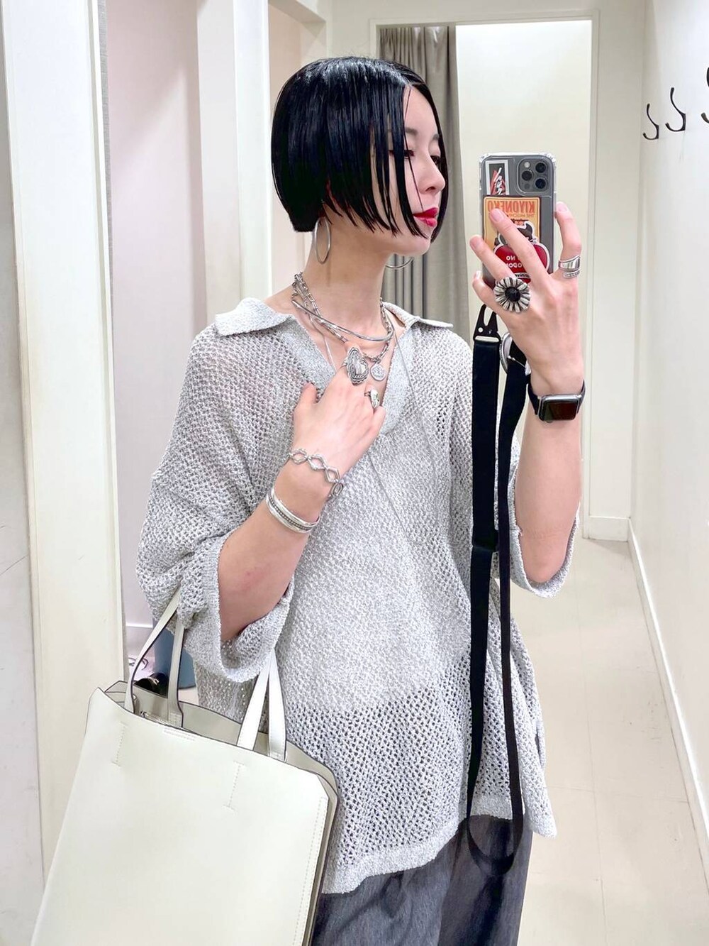 ホワイト系のトートバッグ、ホワイト系のキャミソール、ブラック系のサンダルを着用したレディースの夏コーディネートの4枚目の写真