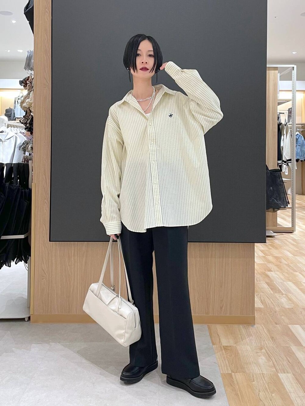 ブラック系のローファー、ブラック系のその他パンツ、ベージュ系のショルダーバッグを着用したレディースの春コーディネートの6枚目の写真