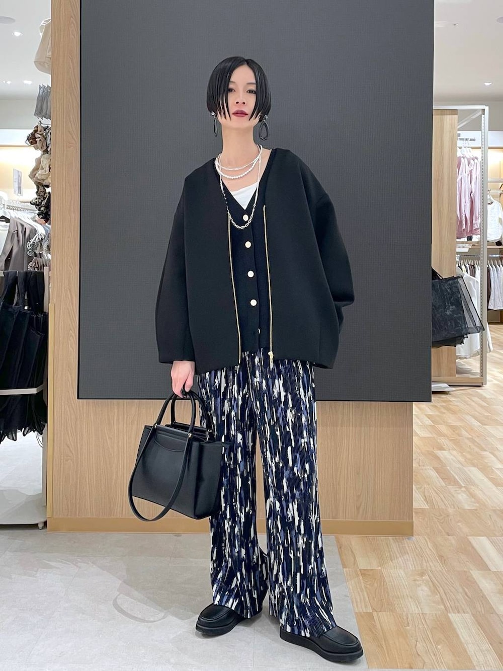 ブラック系のローファー、ブラック系のブルゾン、ブラック系のトートバッグを着用したレディースの春コーディネートの5枚目の写真