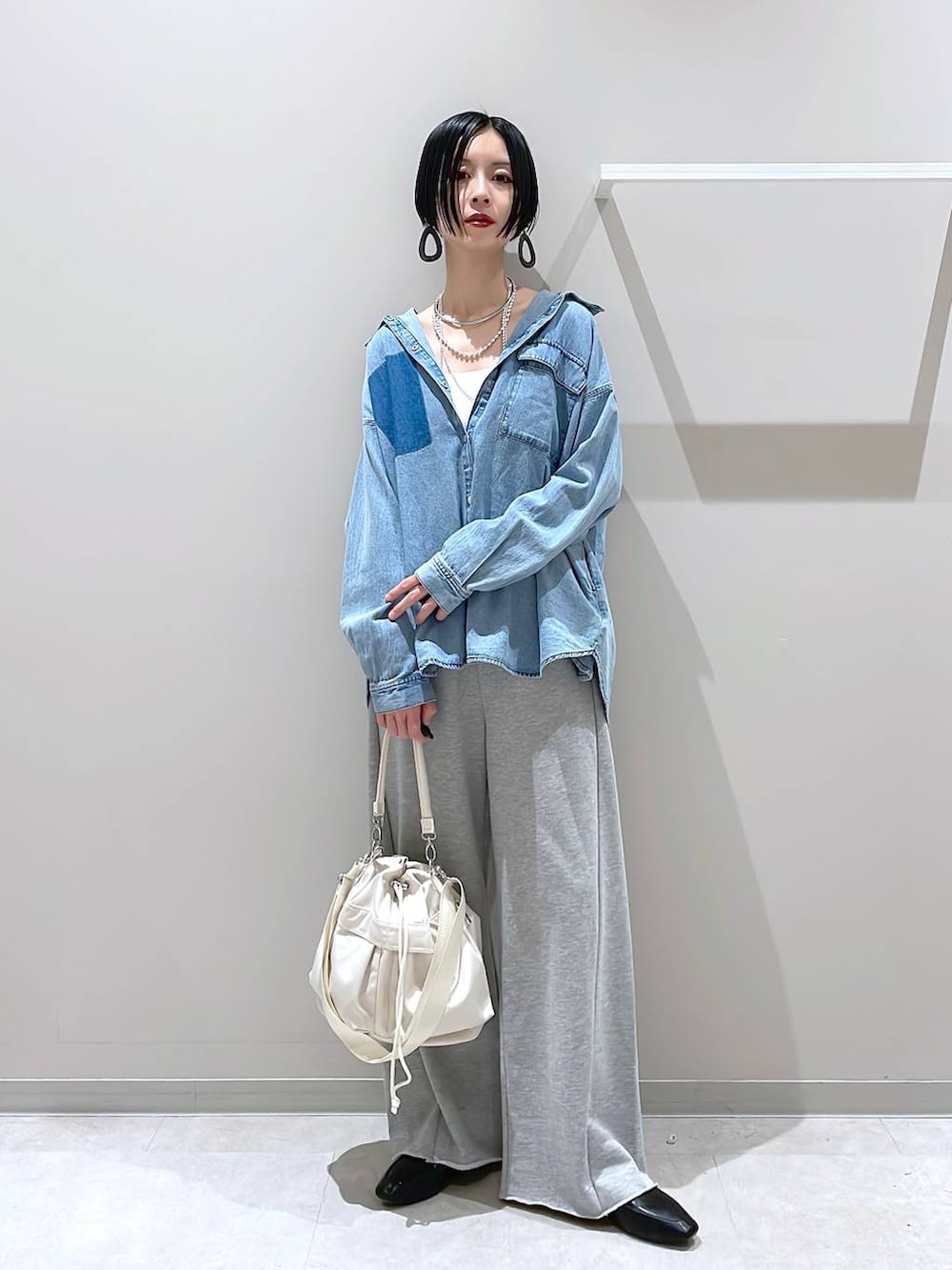 ブラック系のその他シューズ、ホワイト系のショルダーバッグ、グレー系のスウェットパンツを着用したレディースの春コーディネートの5枚目の写真