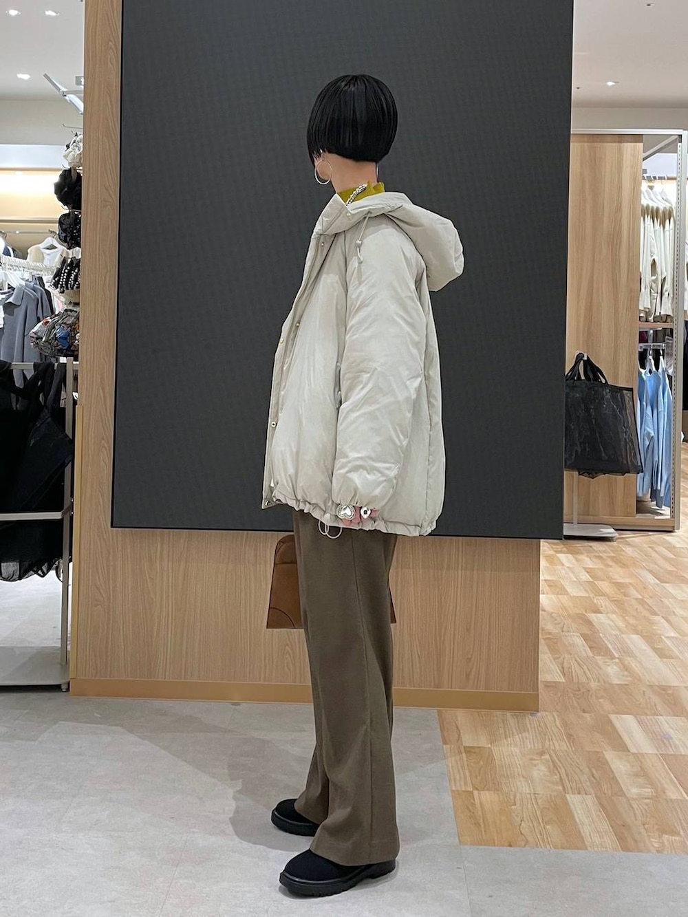 ベージュ系のダウンジャケット/コート、ブラウン系のその他パンツ、ベージュ系のショルダーバッグを着用したレディースの冬コーディネートの5枚目の写真