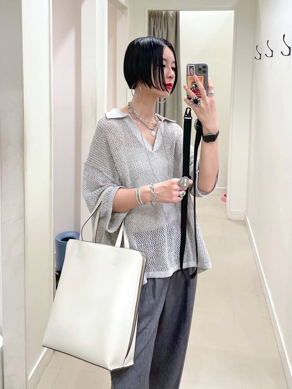 ホワイト系のトートバッグ、ホワイト系のキャミソール、ブラック系のサンダルを着用したレディースの夏コーディネートの3枚目の写真