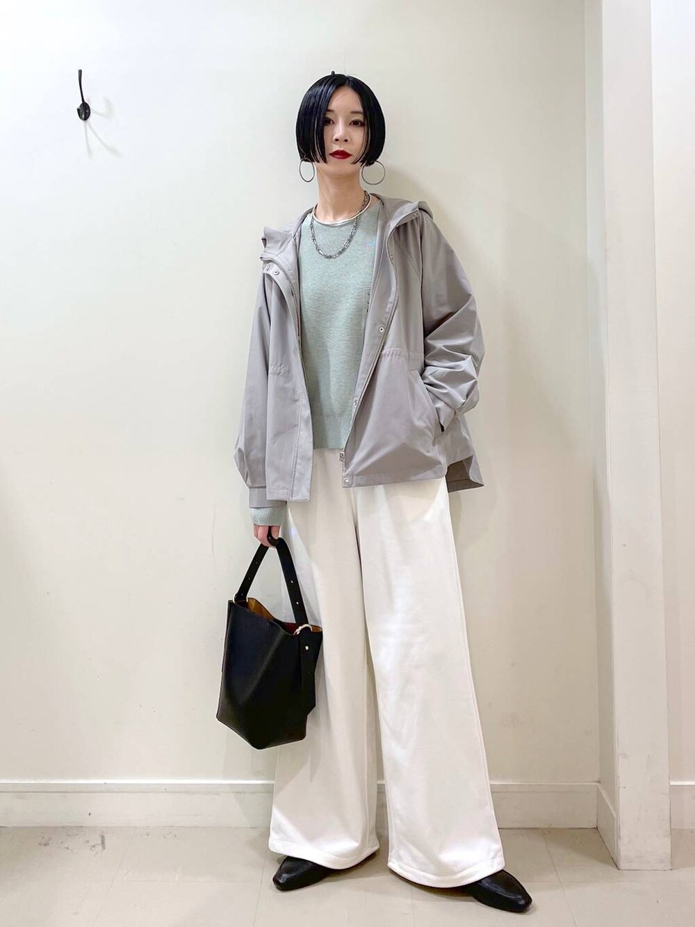 ブラック系のその他シューズ、グリーン系のマウンテンパーカー、ブラック系のショルダーバッグを着用したレディースの春コーディネートの2枚目の写真